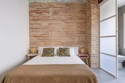a bedroom with a brick wall and a bed at Céntrica y encantadora vivienda. in Valencia
