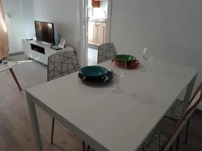 a white table with two plates and wine glasses on it at MALVARROSA BEACH FAMILIAR in Valencia
