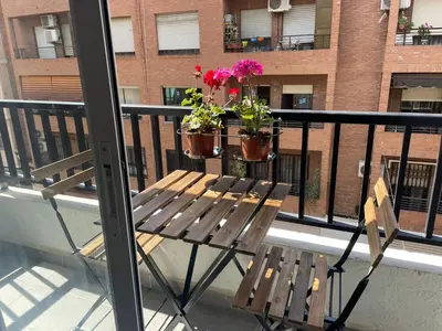a balcony with a bench and two potted plants at Arts and Sciens Museum/Beach in Valencia