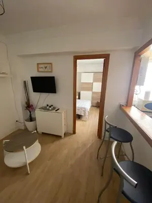 a living room with a television and a table and chairs at Arts and Sciens Museum/Beach in Valencia