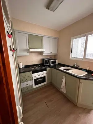 a small kitchen with white cabinets and a sink at Apartamento Tavernes Playa in Tavernes de Valldigna