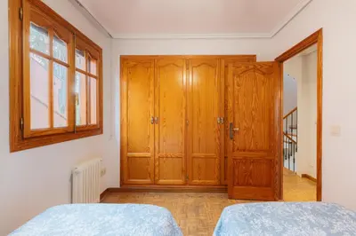 a bedroom with a wooden closet and a door at chalet, villa rodeada de naturaleza piscina a doce klm de Valencia y 7 del aeropuerto in Valencia