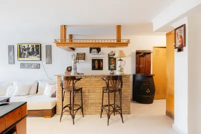 a living room with a brick fireplace with bar stools at chalet, villa rodeada de naturaleza piscina a doce klm de Valencia y 7 del aeropuerto in Valencia