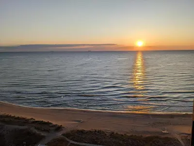 a sunset over the ocean with the sun setting at Apartamento prémium con 5 Piscinas Barbacoa Tenis Frontenis in Mareny Blau
