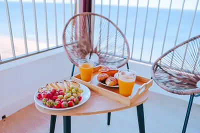 a table with a tray of food and two glasses of orange juice at Apartamento prémium con 5 Piscinas Barbacoa Tenis Frontenis in Mareny Blau