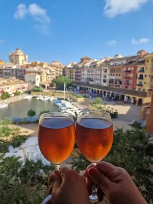 two people holding wine glasses with a view of a river at Port Saplaya 1 Valencia in Port Saplaya