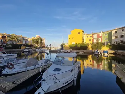 a group of boats docked in a marina with buildings at Port Saplaya 1 Valencia in Port Saplaya