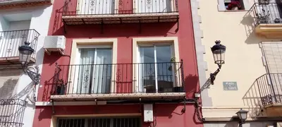 a red building with balconies and a street light at La Viajera Espadan in Algimia de Almonacid
