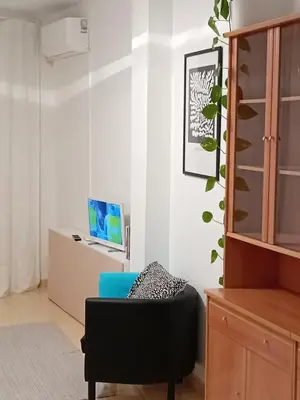 a living room with a blue chair and a cabinet at La Viajera Espadan in Algimia de Almonacid