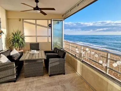 a balcony with a table and chairs and the ocean at Apartmán pri mori in El Brosquil