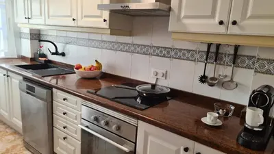 a kitchen with white cabinets and a bowl of fruit on the counter at Apartmán pri mori in El Brosquil