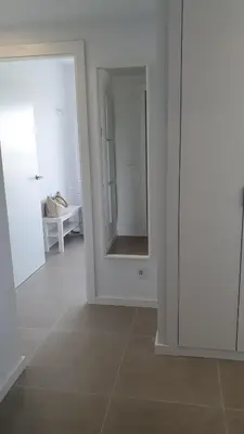 a white room with a door and a mirror at Apartamento con vistas en Gran Canet in Canet de Berenguer