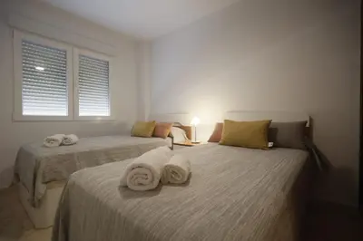 two beds with towels on them in a bedroom at LA CULLERINA playa San Antonio con Internet Alta Velocidad Aire Acondicionado in Cullera