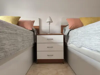 two twin beds with a nightstand in a bedroom at LA CULLERINA playa San Antonio con Internet Alta Velocidad Aire Acondicionado in Cullera