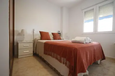 a white bedroom with a bed and a window at LA CULLERINA playa San Antonio con Internet Alta Velocidad Aire Acondicionado in Cullera