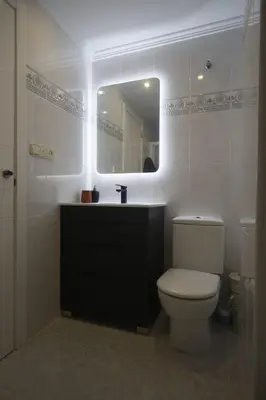 a bathroom with a toilet and a sink and a mirror at LA CULLERINA playa San Antonio con Internet Alta Velocidad Aire Acondicionado in Cullera