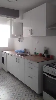 a kitchen with white cabinets and a sink and a stove at Nice Spacious Flat in the Center in Valencia