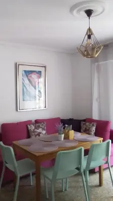 a dining room table with chairs and a purple couch at Nice Spacious Flat in the Center in Valencia