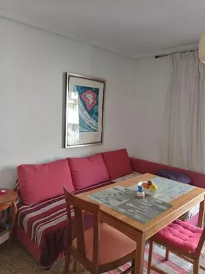 a living room with a red couch and a table at Nice Spacious Flat in the Center in Valencia
