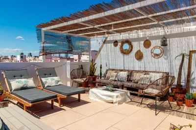 a patio with a couch and chairs on a roof at Precioso ático en Valencia. in Valencia
