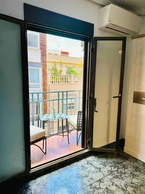a room with a sliding glass door to a balcony at Playa Bonita Apartment in Puerto de Sagunto