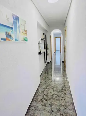 a hallway with white walls and a tile floor at Playa Bonita Apartment in Puerto de Sagunto