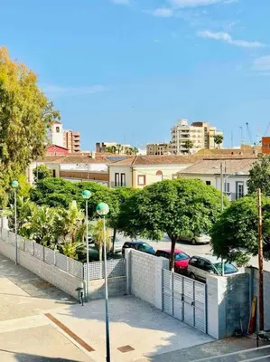 a view of a parking lot with a fence and cars at Playa Bonita Apartment in Puerto de Sagunto
