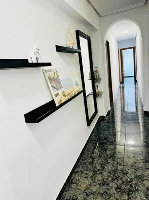 a hallway with white walls and a mirror on the wall at Playa Bonita Apartment in Puerto de Sagunto