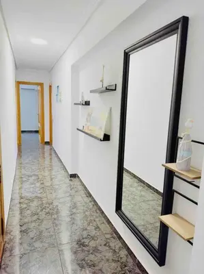 a mirror on a wall next to a hallway at Playa Bonita Apartment in Puerto de Sagunto