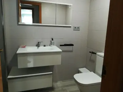 a bathroom with a sink and a toilet and a mirror at Mi playa in Puerto de Sagunto