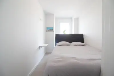 a white bedroom with a bed and a window at Global Vacacional, Apartamento de 2 habitaciones con gran terraza en Gran Canet in Canet de Berenguer