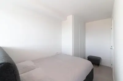 a small white bedroom with a bed and a window at Global Vacacional, Apartamento de 2 habitaciones con gran terraza en Gran Canet in Canet de Berenguer