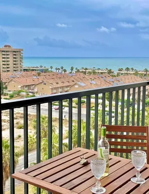 a wooden table with a bottle and glasses on a balcony at Valencia Beach Home 23 in Valencia