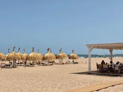 a beach with umbrellas and people sitting on the sand at Valencia Beach Home 23 in Valencia