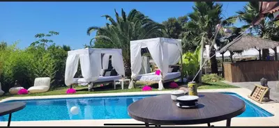 a swimming pool with a table and chairs next to a house at Villas de descanso in Vilamarxant