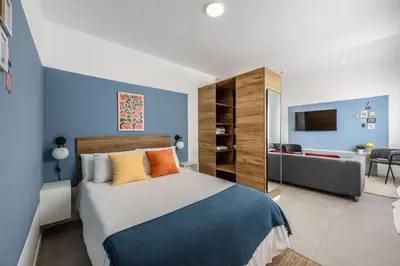 a bedroom with a large bed with blue walls at AmazINN Places Valencia Cabanyal in Valencia