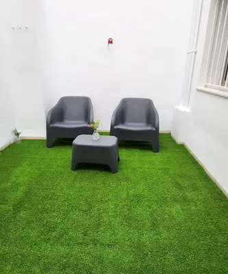 two chairs and a table in a room with green grass at Apartamento en Les Alqueries con aire acondicionado in Alquerías del Niño Perdido