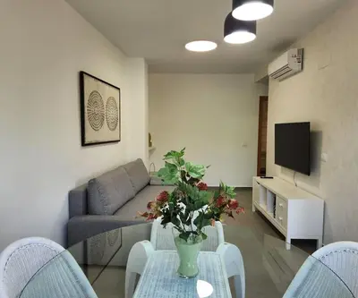 a living room with a couch and a table with a vase at Apartamento en Les Alqueries con aire acondicionado in Alquerías del Niño Perdido