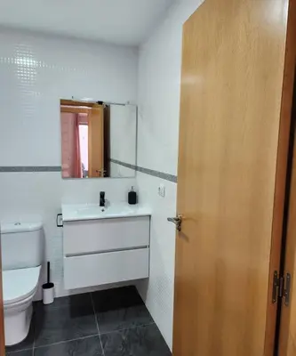 a bathroom with a toilet and a sink and a door at Apartamento en Les Alqueries con aire acondicionado in Alquerías del Niño Perdido