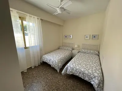 a bedroom with two beds and a ceiling fan at Apartamento familiar en Cullera - Playa el Racó in Cullera