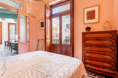 a bedroom with a bed and a dresser and a window at Casa Rosario Cabanyal flat near the beach, high end in Valencia