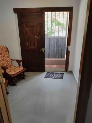 a living room with a door and a chair and a rug at Casa Coletor in Chulilla