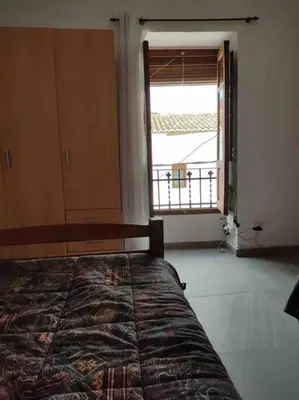 a bedroom with a bed and a large window at Casa Coletor in Chulilla