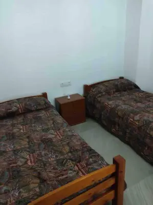 a bedroom with two beds and a night stand at Casa Coletor in Chulilla