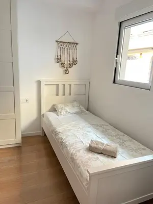 a bed in a bedroom with a window and a chandelier at UIM Mediterraneo PB Virgen del Carmen Wifi in Puerto de Sagunto