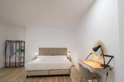 a bedroom with a bed and a desk with a lamp at Cid 90 Flat by Concept in Valencia