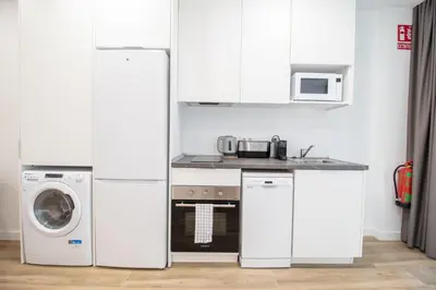 a kitchen with a refrigerator and a washing machine at Cid 90 Flat by Concept in Valencia