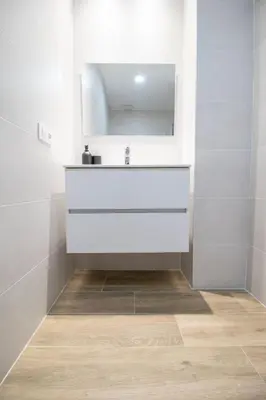 a white bathroom with a sink and a mirror at Cid Flats by Concept in Valencia