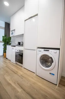 a kitchen with a washing machine in a white kitchen at Cid Flats by Concept in Valencia