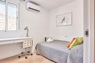 a bedroom with a bed and a desk and a window at SPACIOUS, SUNNY FLAT BY CITY OF ARTS & SCIENCES in Valencia